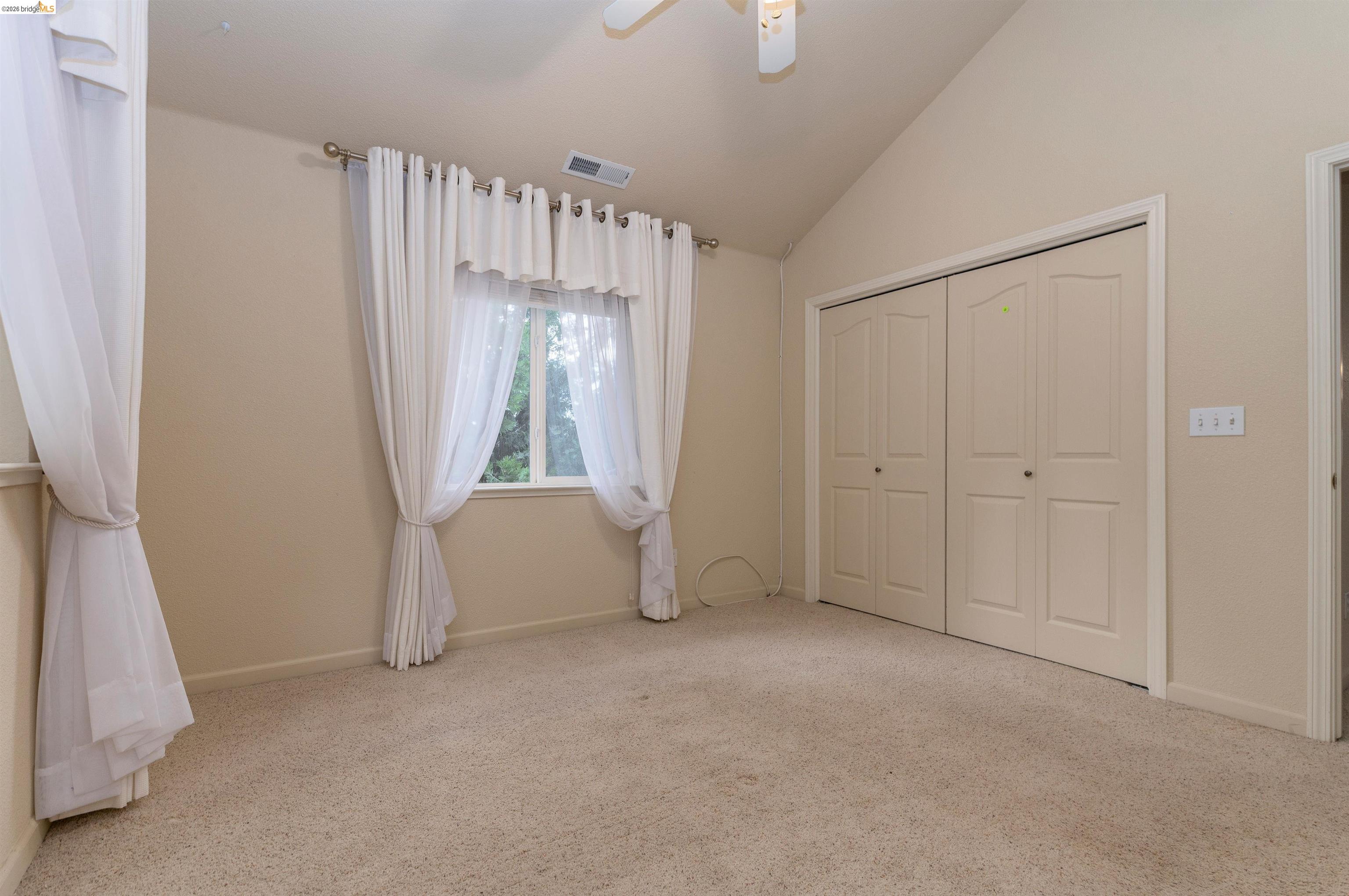 22401 Ridge Road Twain Harte, CA 95383 - Photo 26 of 56 Vaulted ceiling with a ceiling fan, neutral carpet, and bi-fold closet doors