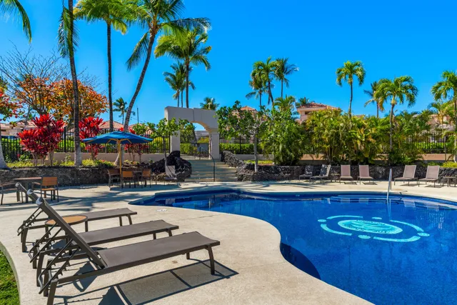 a front view of a house with a yard and potted plants