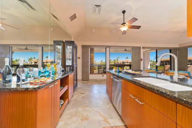 a kitchen with granite countertop a sink a counter top space and living room view