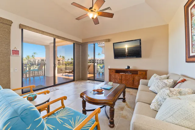 a living room with furniture and a view of kitchen