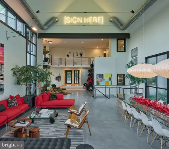 a living room with furniture kitchen view and a wooden floor