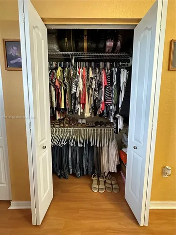 a view of walk in closet with clothes and shoes