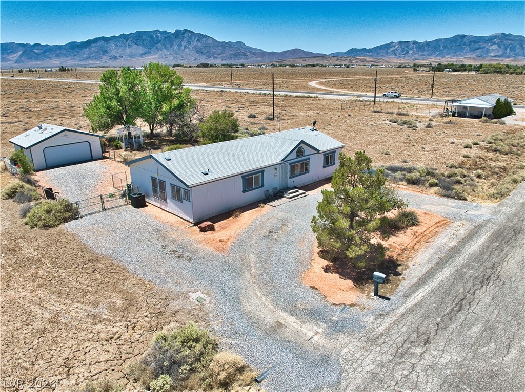 2931 Rio Rancho Drive, Unit 4 Pahrump, NV 89048 - Photo 1 of 21 Perched on a vast desert expanse, this property features a detached garage and a tree-shaded gravel driveway.