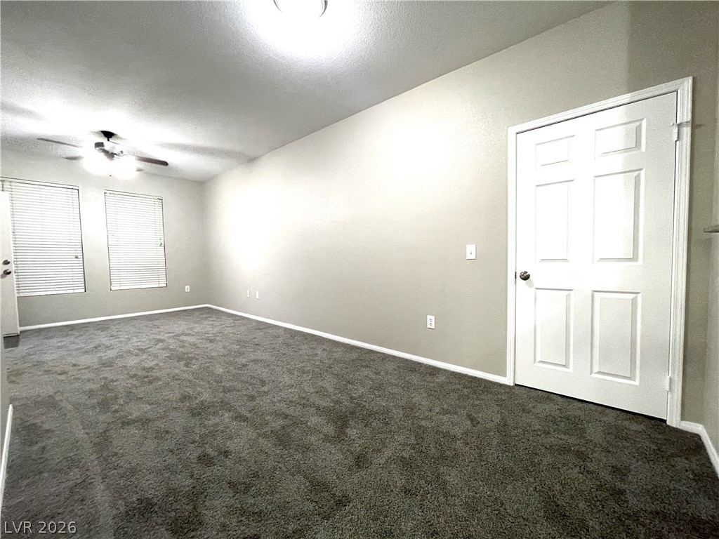 10001 Peace Way, Unit 1327 Las Vegas, NV 89147 - Photo 11 of 21 A well-lit, neutral-toned room featuring a ceiling fan and plush carpeting, offering a comfortable living space.