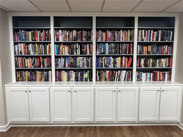 a living room with furniture a piano and a bookshelf