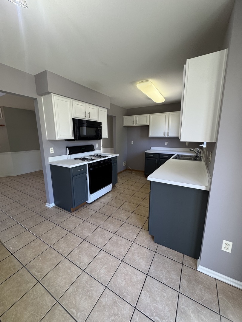 1716 William Drive Romeoville, IL 60446 - Photo 5 of 18 a kitchen with stainless steel appliances a stove a sink and a refrigerator
