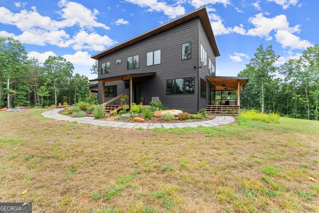 a kitchen with stainless steel appliances kitchen island granite countertop a table chairs sink and cabinets