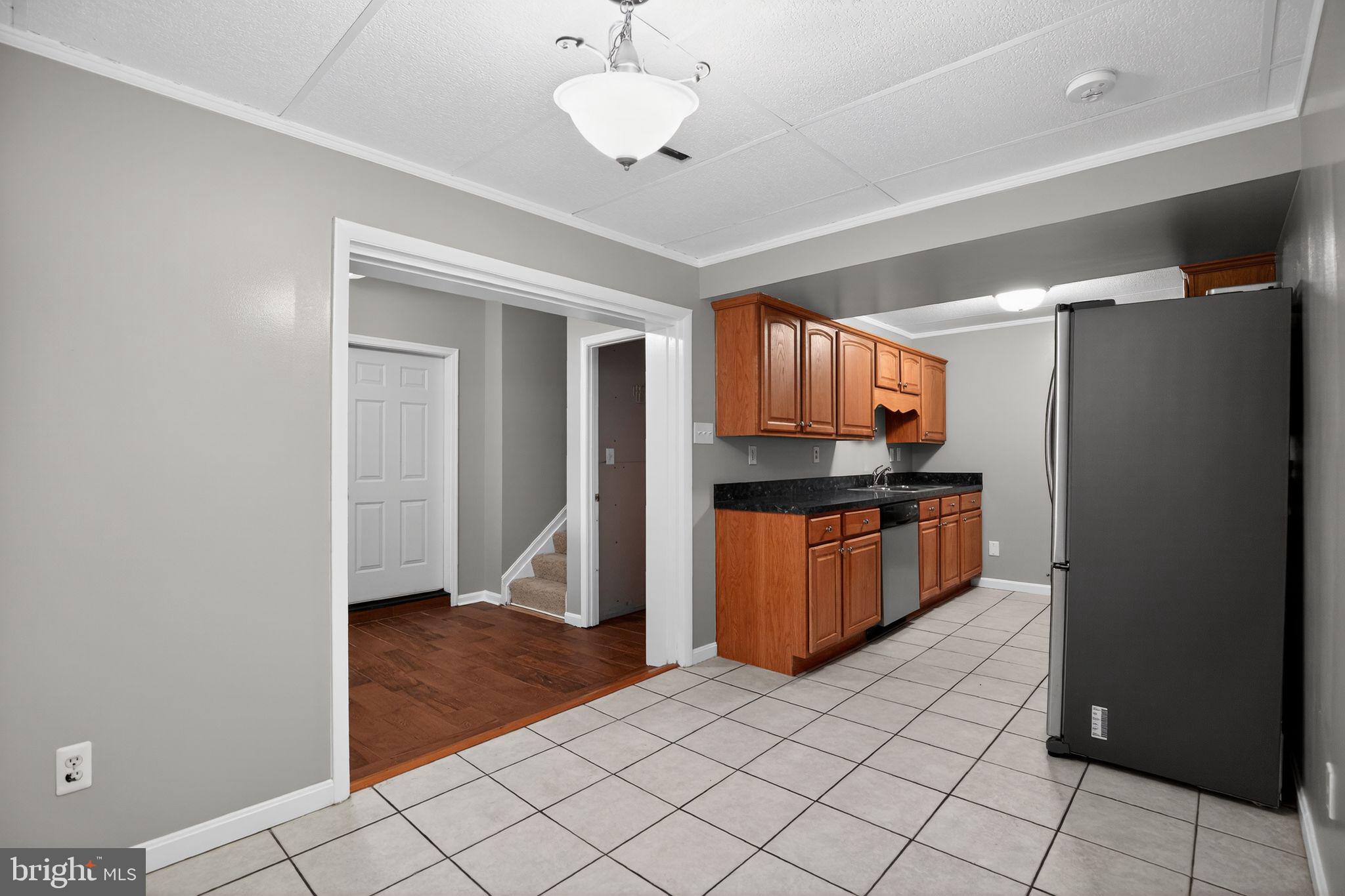 40855 Spring House Lane Leonardtown, MD 20650 - Photo 34 of 68 a kitchen with granite countertop a refrigerator and a stove top oven