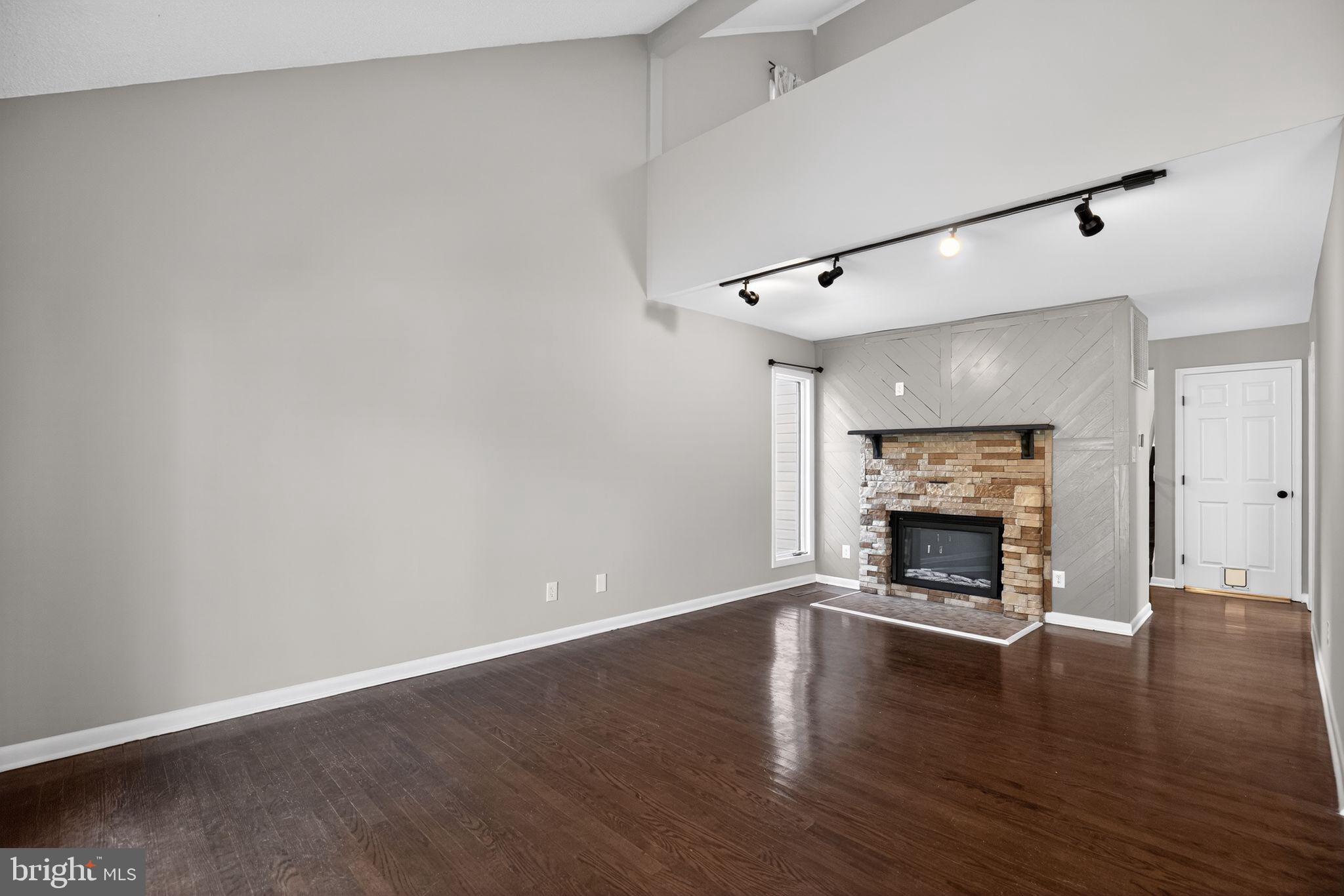 40855 Spring House Lane Leonardtown, MD 20650 - Photo 7 of 68 a view of an empty room with wooden floor fireplace and a window