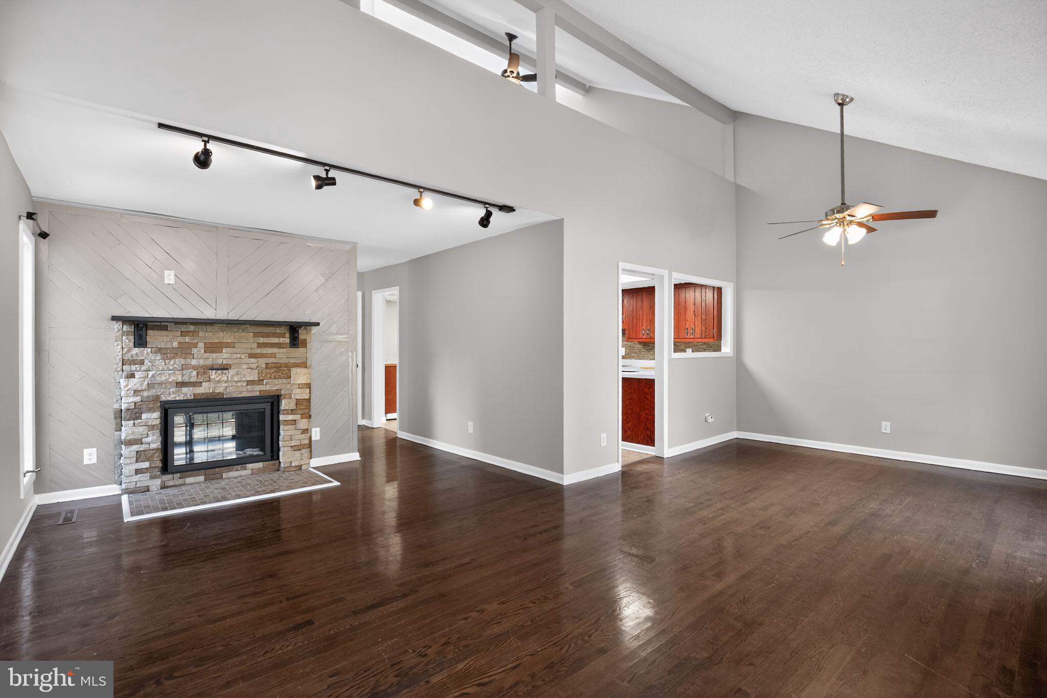 40855 Spring House Lane Leonardtown, MD 20650 - Photo 9 of 68 a view of an empty room with wooden floor fireplace and a window