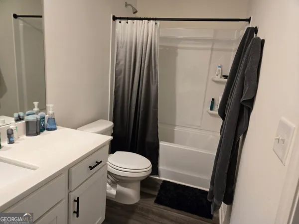 a bathroom with a sink a toilet a mirror and shower