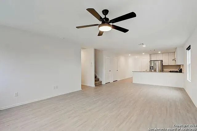 a view of a livingroom with a ceiling fan and wooden floor