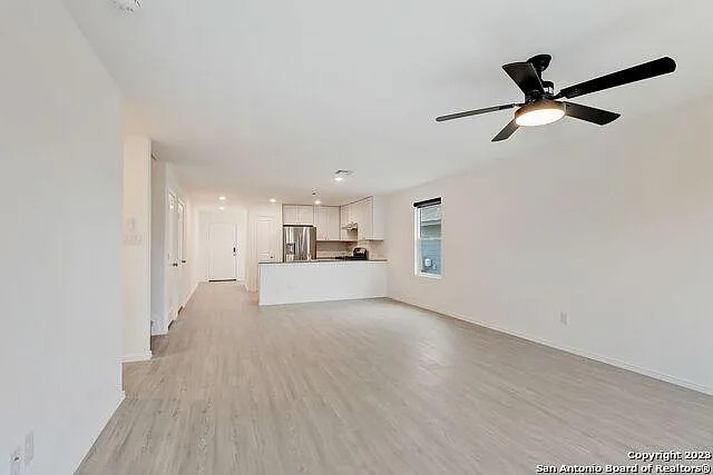 10707 Margarita Loop Converse, TX 78109 - Photo 9 of 32 Unfurnished living room with light wood finished floors and a ceiling fan
