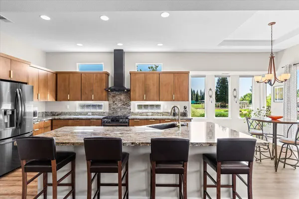 a kitchen with stainless steel appliances granite countertop a sink stove and refrigerator