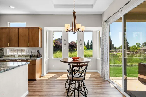 a kitchen with granite countertop kitchen island stainless steel appliances a sink stove and cabinets