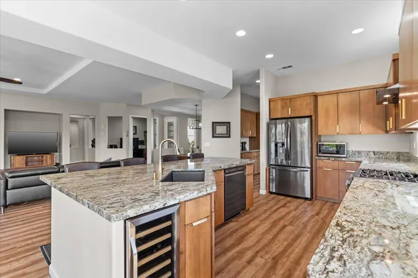 a dining room with wooden floor a chandelier a wooden table and chairs