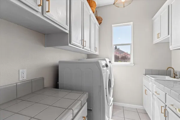 a bathroom with a double vanity sink a large mirror a bathtub and shower