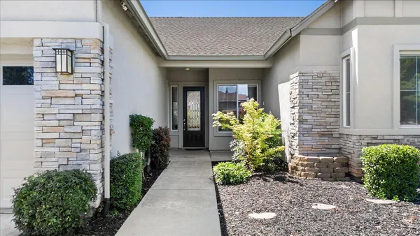 a view of a hallway with wooden floor and a living room