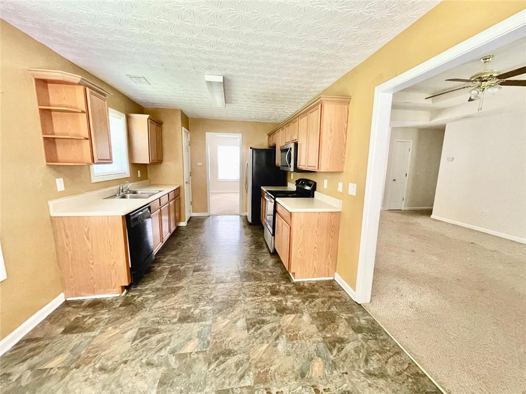 127 Mabry Road Jackson, GA 30233 - Photo 5 of 13 a kitchen with stainless steel appliances granite countertop a stove a sink and a refrigerator