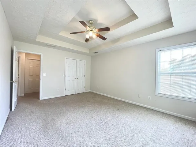 an empty room with windows and fan