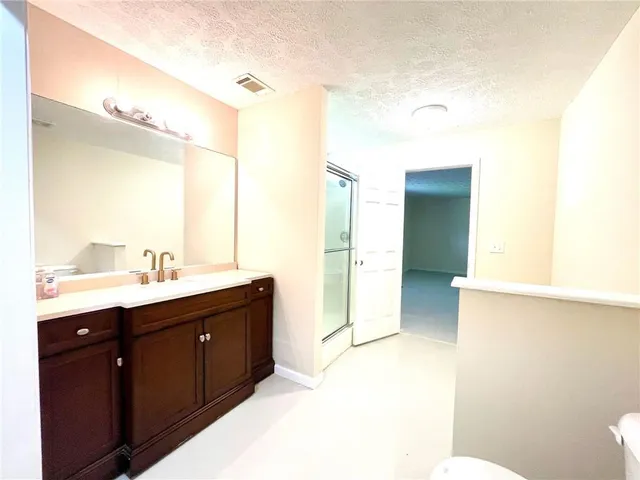 a bathroom with a double vanity sink toilet and mirror
