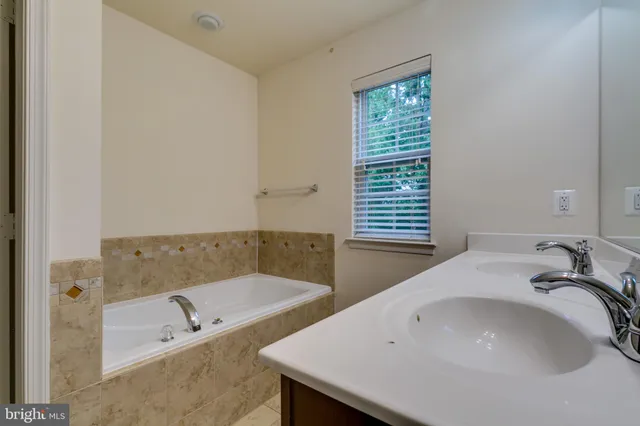 a view of an empty room with chandelier fan and a window