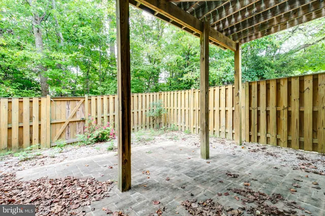 a backyard of a building with wooden fence and a bench