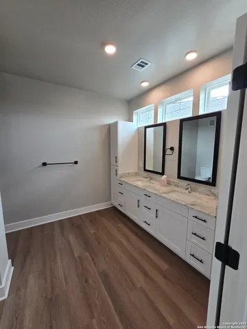 a bathroom with double vanity and a mirror