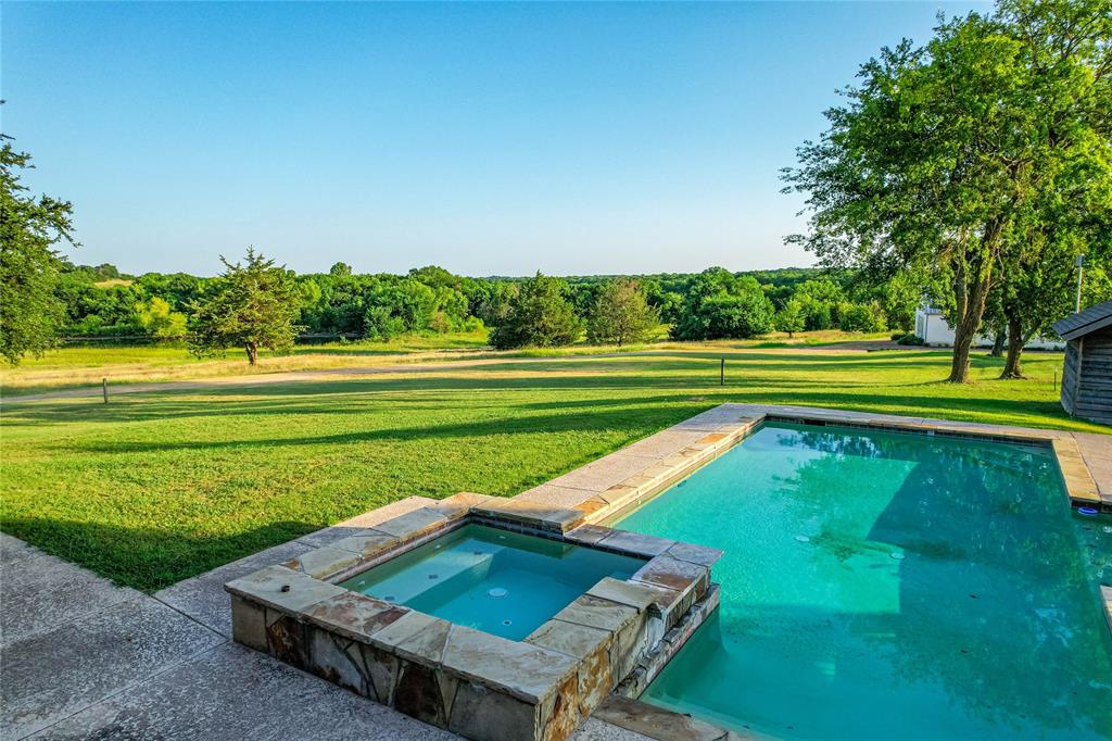 1922 A Bethel-Cannon Road Whitewright, TX 75491 - Photo 20 of 40 Swimming pool and spa with flagstone coping and stone veneer surround
