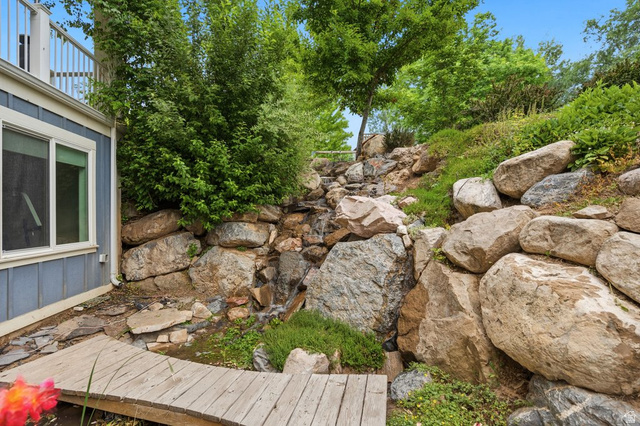672 Perry Hollow Drive Mapleton, UT 84664 - Photo 104 of 106 Expansive rock garden with a multi-tiered water feature, natural stone landscaping, and lush green foliage