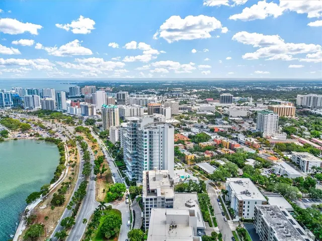 a view of a hallway with wooden floor and a bathroom
