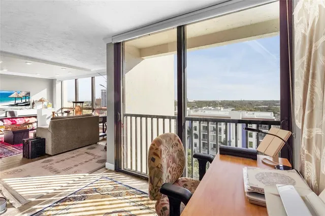 a spacious bedroom with a bed a table and large windows