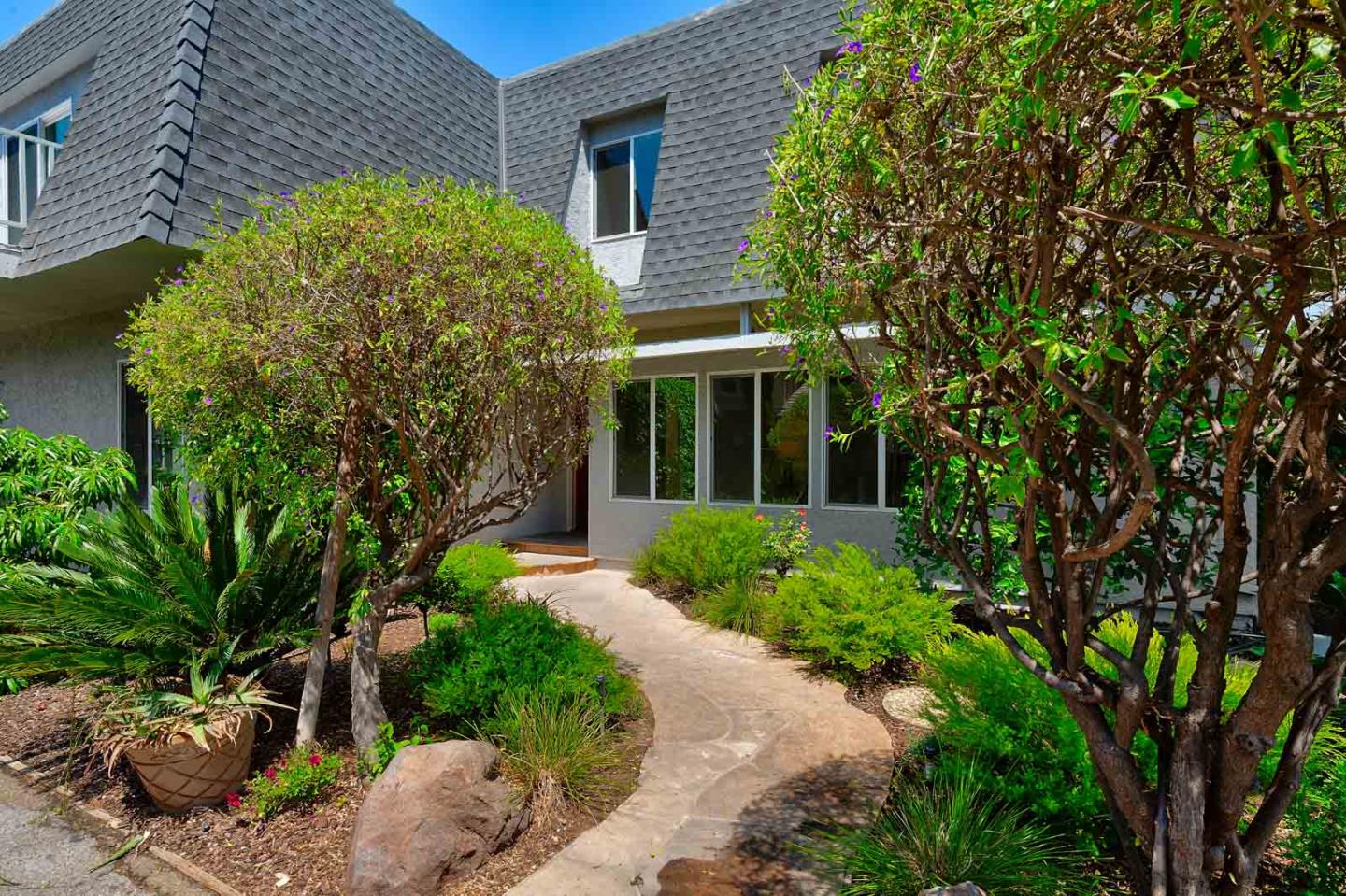 106 Springer Road Los Altos, CA 94024 - Photo 2 of 52 a view of a house with brick walls plants and large tree