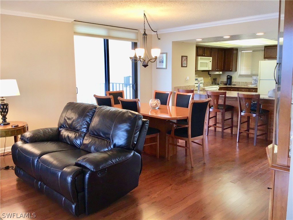 15021 Punta Rassa Road, Unit 704 Fort Myers, FL 33908 - Photo 3 of 18 a living room with furniture dining table and a chandelier