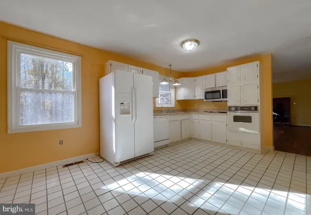 a kitchen with white cabinets and white appliances