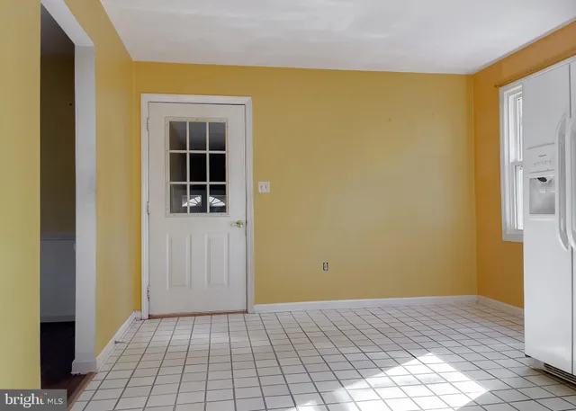 a kitchen with white cabinets and refrigerator