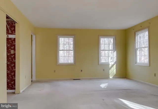a view of an empty room with a fireplace and a window