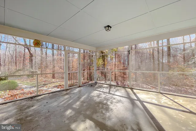 a backyard of a house with large trees and outdoor seating