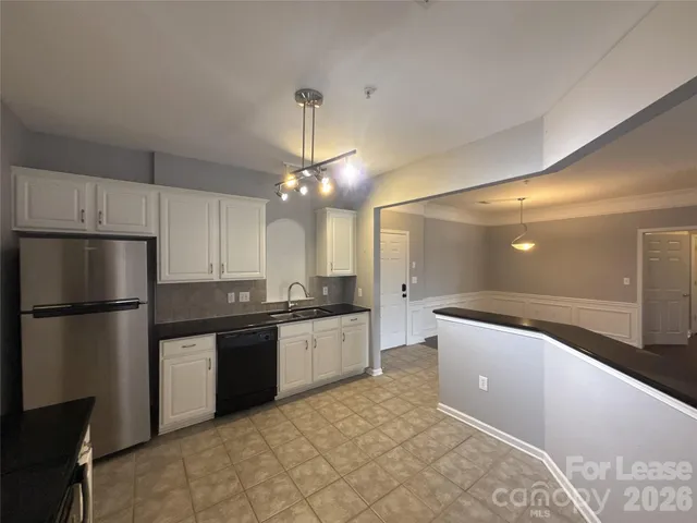 a kitchen with stainless steel appliances granite countertop a sink a stove a refrigerator and island