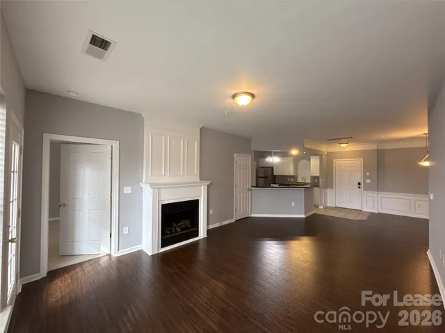 an empty room with floor to ceiling window and fireplace