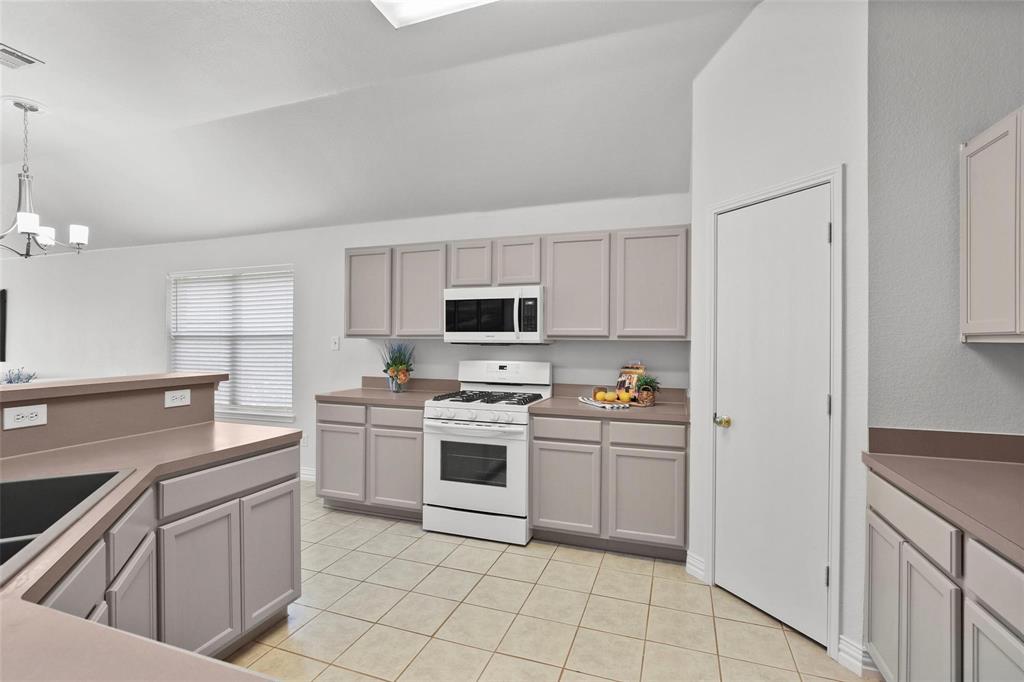 5961 Cheyenne Way Frisco, TX 75034 - Photo 7 of 33 Kitchen featuring light gray cabinetry, laminate countertops, a white gas range, and a built-in microwave