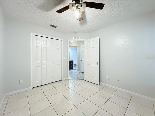 an empty room with closet and a chandelier fan