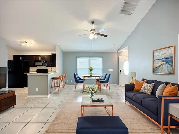 a living room with furniture and kitchen view