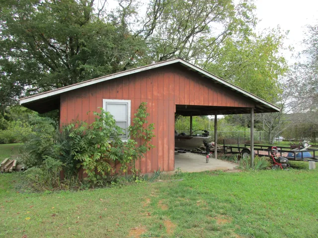 a backyard of a house with table and chairs under an umbrella