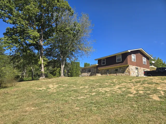 a big house with large tree in front of it