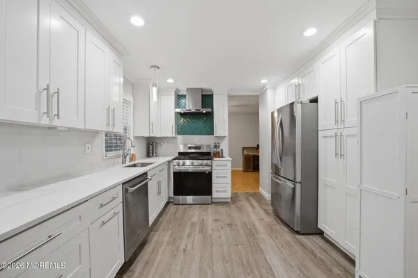 a kitchen with a refrigerator a sink and a stove top oven