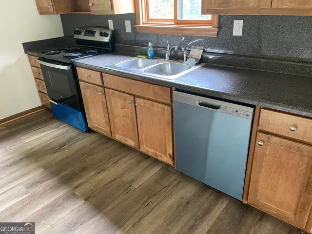 a kitchen with a sink a stove and cabinets