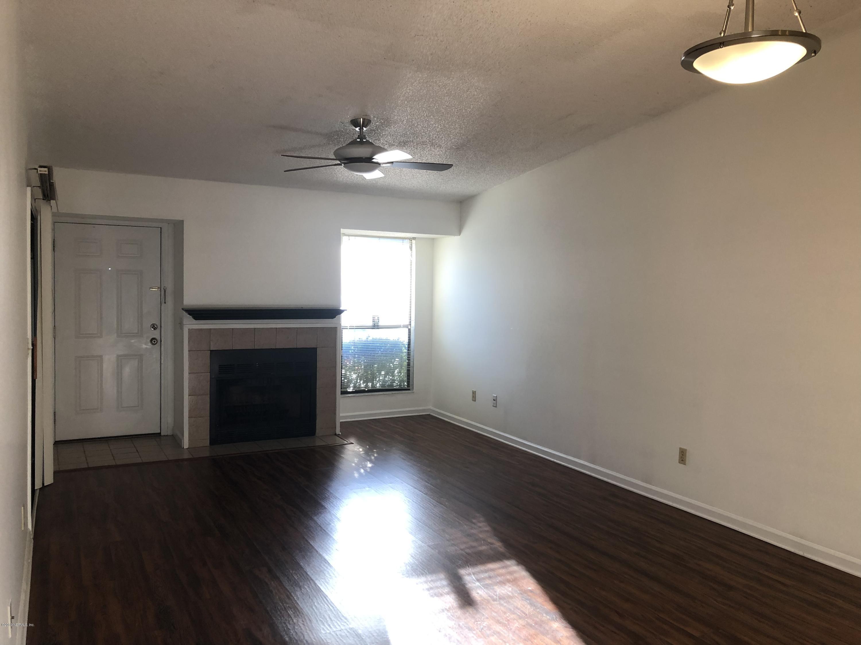 3801 Crown Point Road, Unit 3023 Jacksonville, FL 32257 - Photo 5 of 18 an empty room with wooden floor fan and window