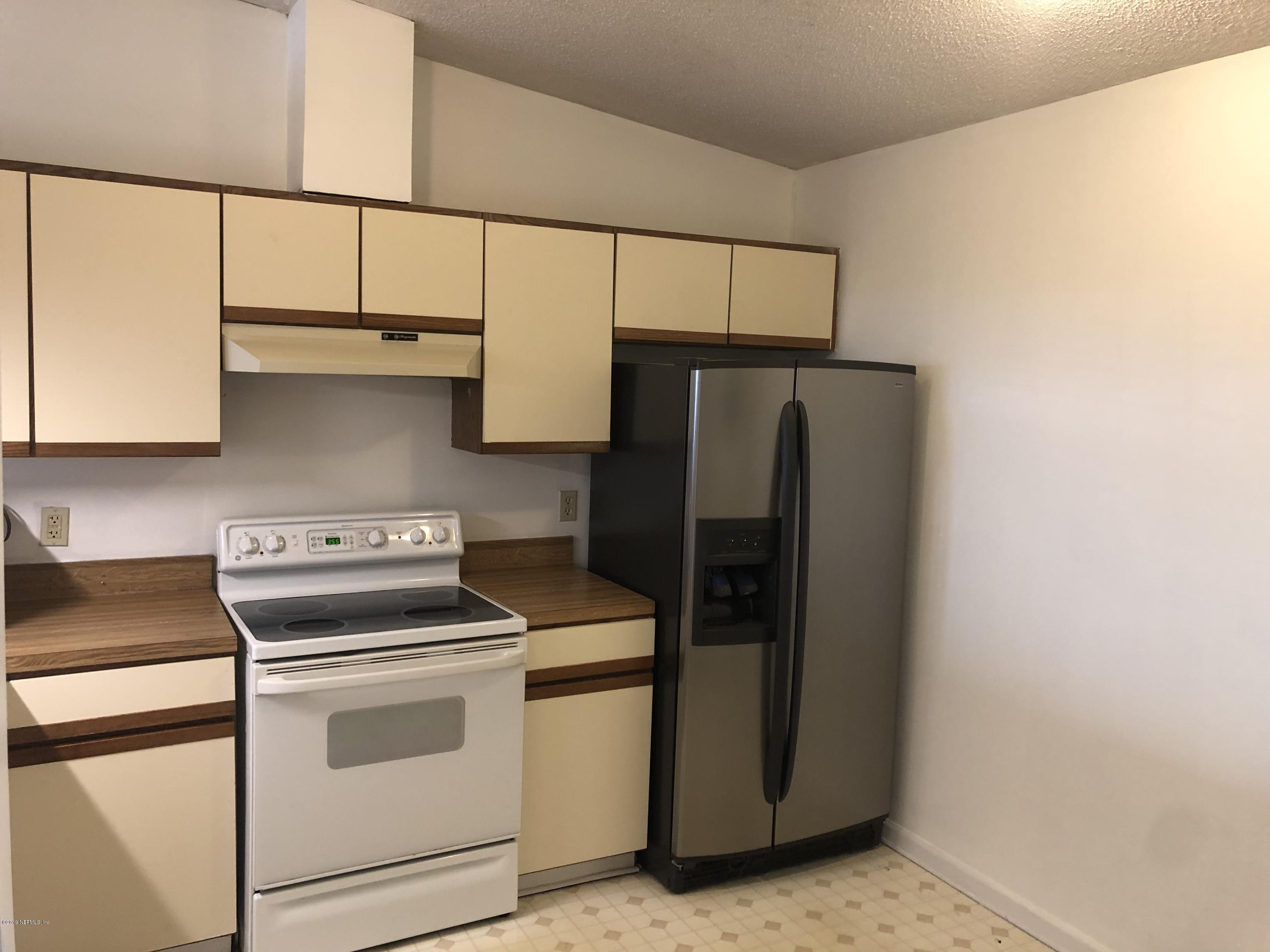 3801 Crown Point Road, Unit 3023 Jacksonville, FL 32257 - Photo 7 of 18 a kitchen with stainless steel appliances a refrigerator sink and cabinets