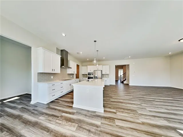 a kitchen with a refrigerator and a stove top oven